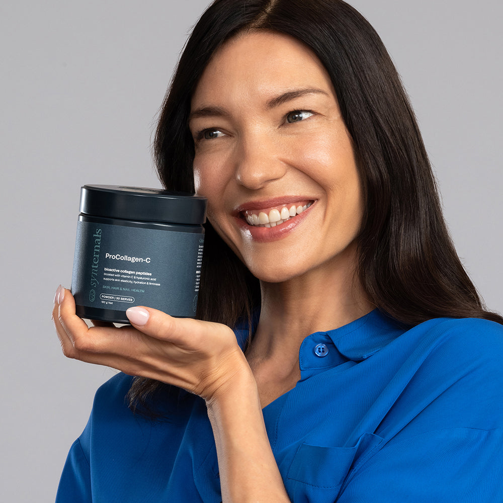 Model smiling while holding ProCollagen-C