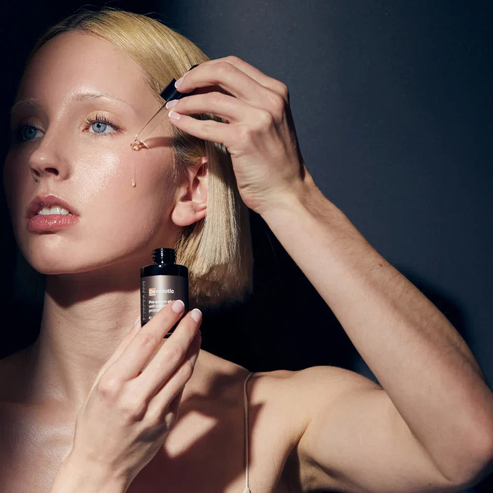 Skincare model applies serum to cheek