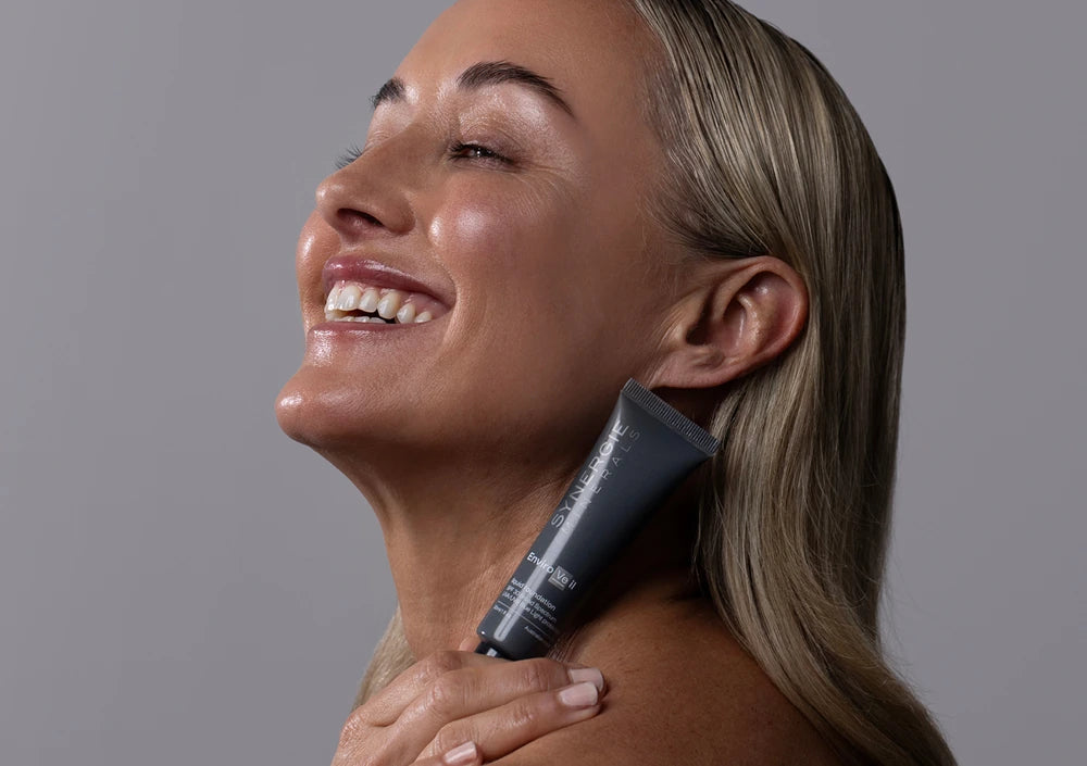 Skincare model is smiling holding EnviroVeil