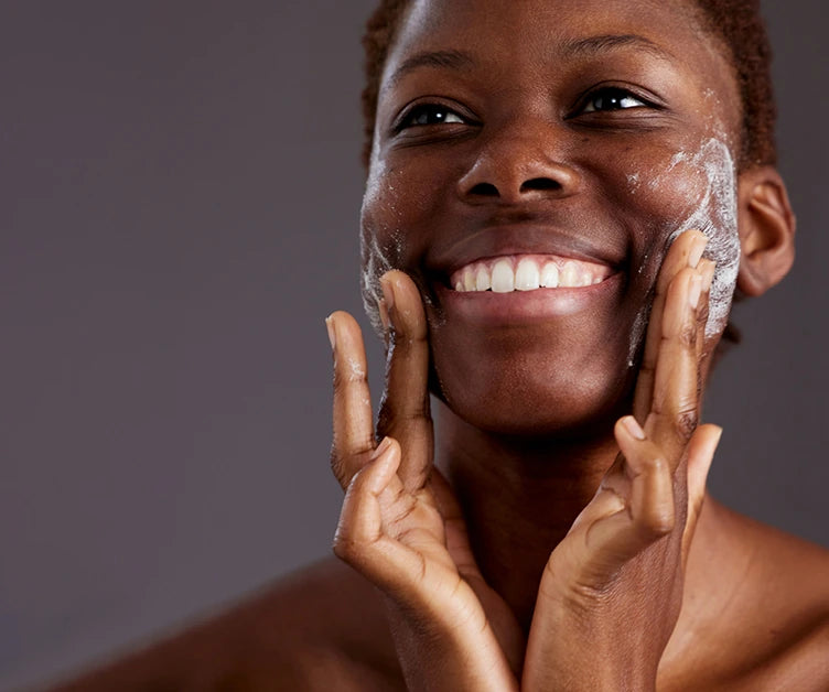 Skincare model is smiling whilst cleaning face
